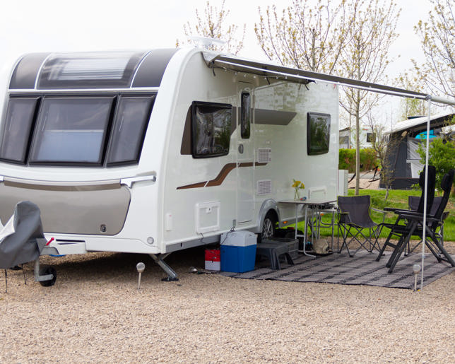 Touring caravan parked on caravan site and set up with chairs and leisure equipment