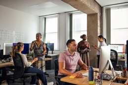 Colleagues work at computers in an office