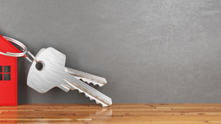 Silver keys attached to a red house-shaped keychain.