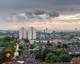 Urban homes standing tall under a stormy sky.