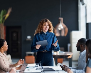 A woman talking to colleagues in a board room