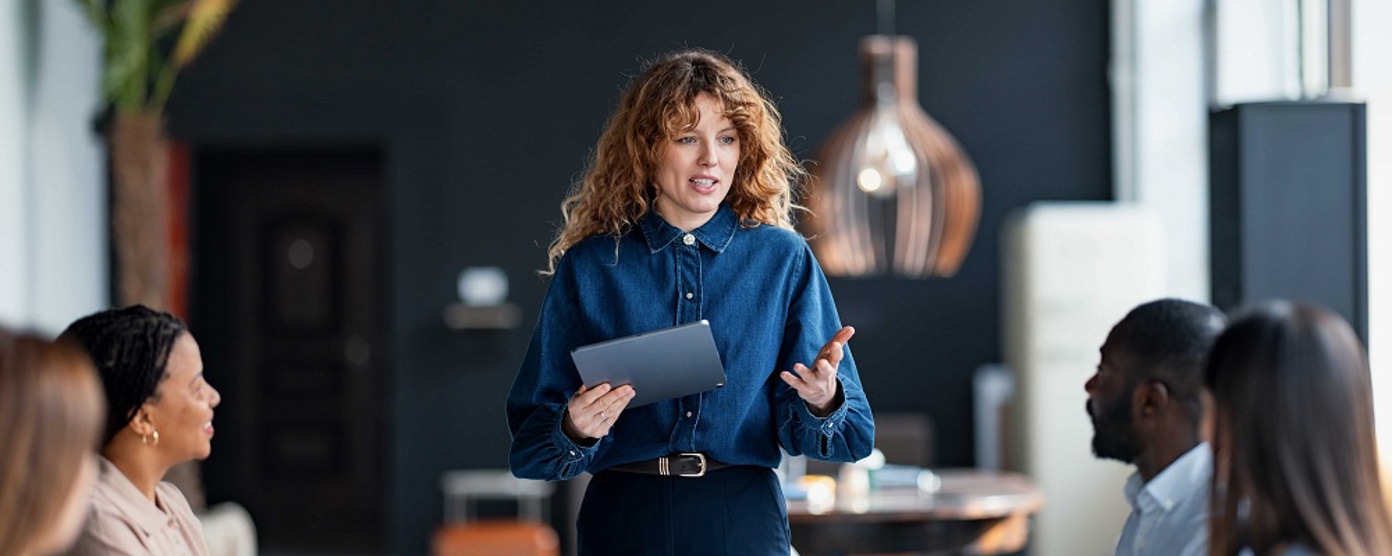 A woman talking to colleagues in a board room