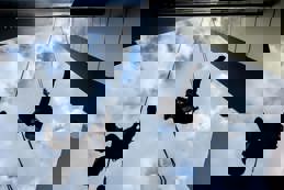 Silhouettes of two industrial climbers are washing, cleaning facade of a modern office building.