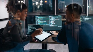 colleagues looking at a monitor in an office