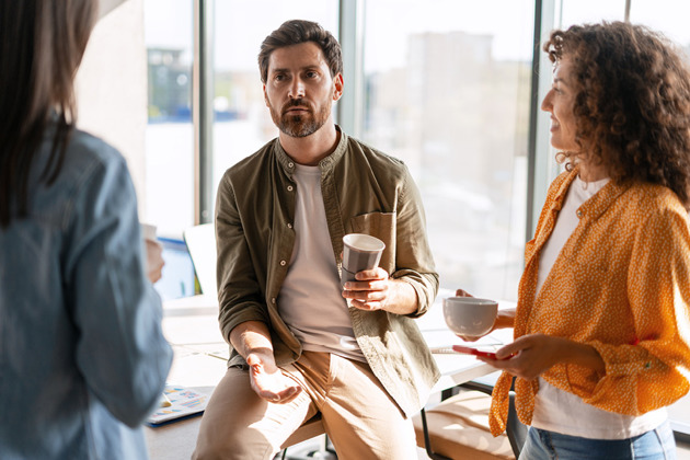 Meeting between three adults over a cup of tea - one man and two women
