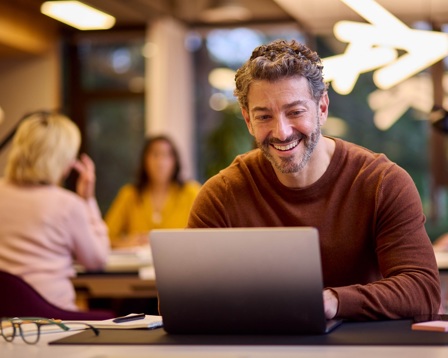 Man smiling using a laptop