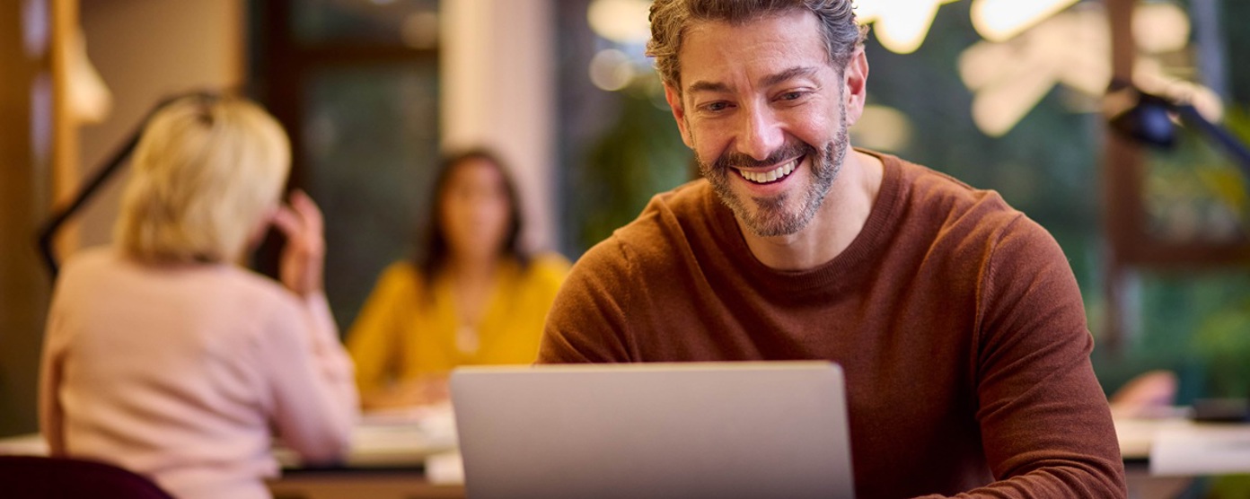Man smiling using a laptop