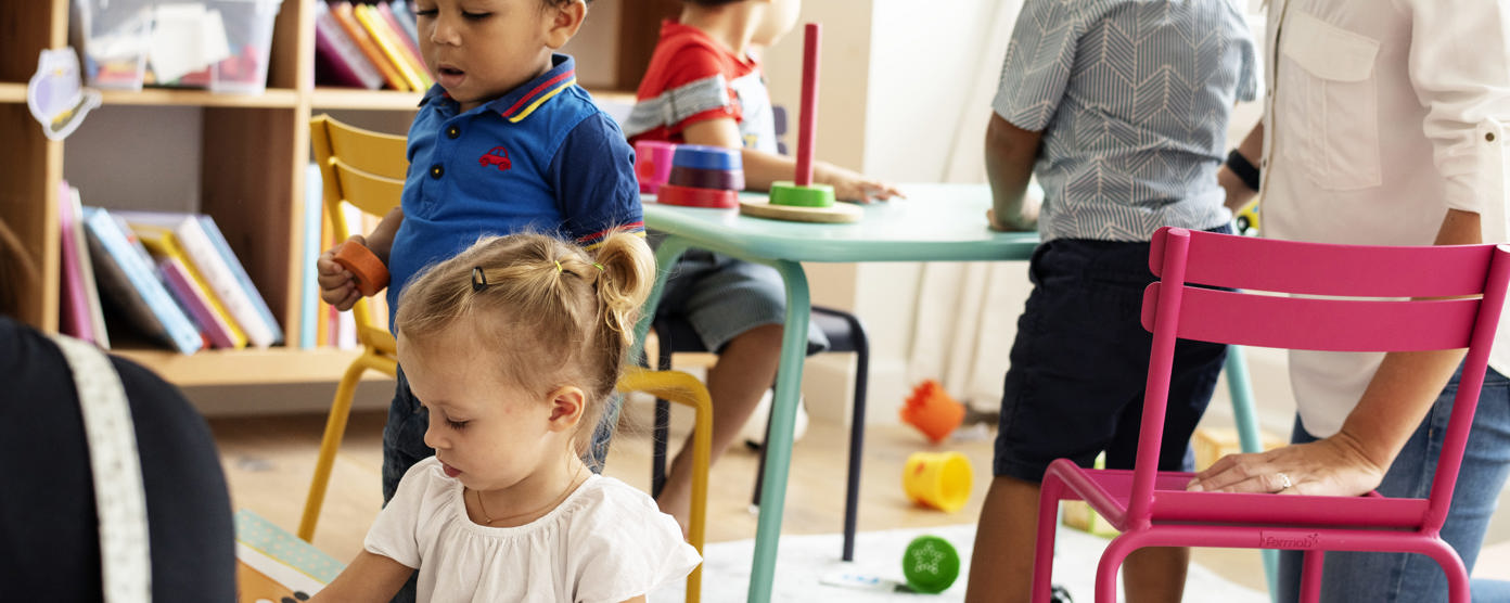 Nursery children playing with teacher