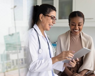 A female doctor and patient smiling in a surgery