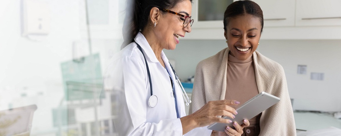 A female doctor and patient smiling in a surgery