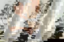 Caregiver supporting elderly man