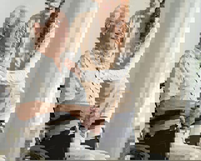 Caregiver supporting elderly man