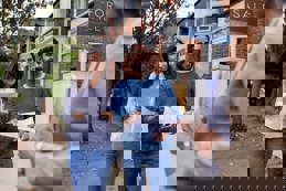 A real estate agent presenting house blueprints to a couple, discussing the property for sale.