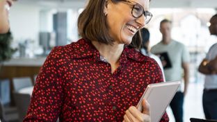 Professional woman holding a laptop and smiling