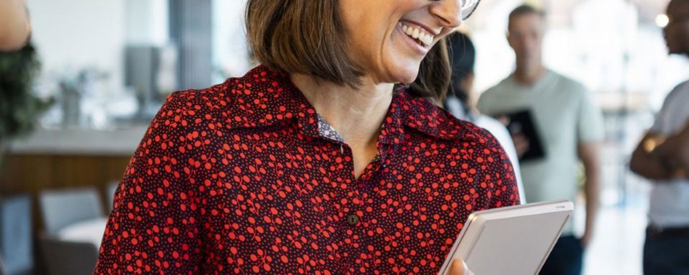 Professional woman holding a laptop and smiling