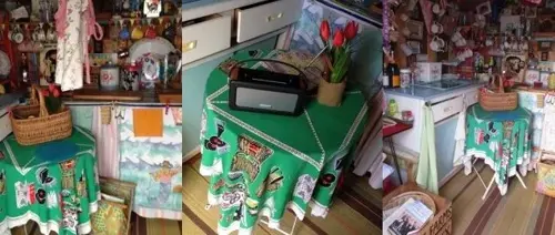 A green tablecloth printed with illustrated figures covers a small table topped with flowers and a radio.