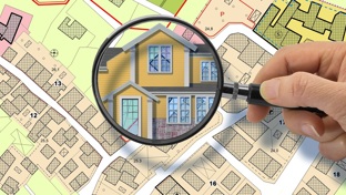 Map with a magnifying glass over a home