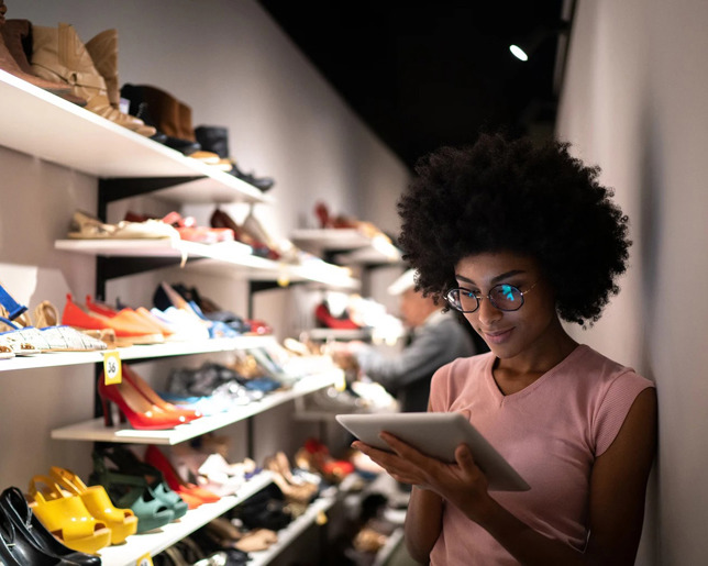 woman in pink on a tablet in a shoe shop
