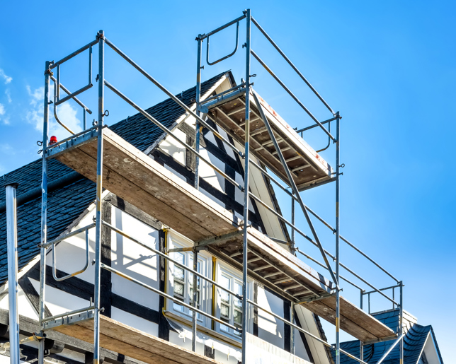 Scaffolding set up around a house, indicating ongoing construction, renovation, or maintenance work.