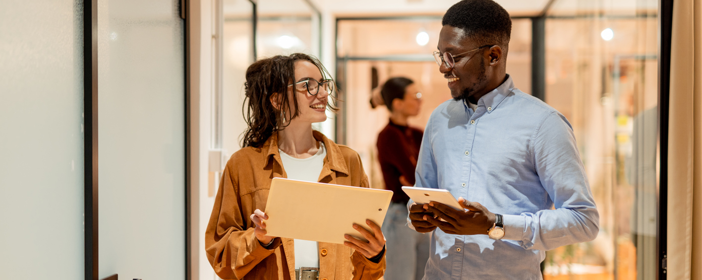Colleagues happily walking and talking about work in a corridor
