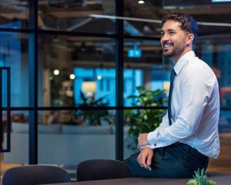Man in a suit sitting on the side of a table