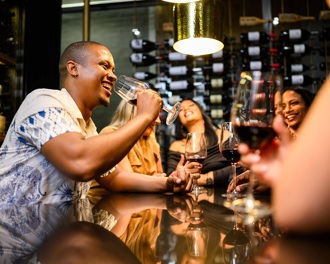 A group of friends smiling and drinking in a bar