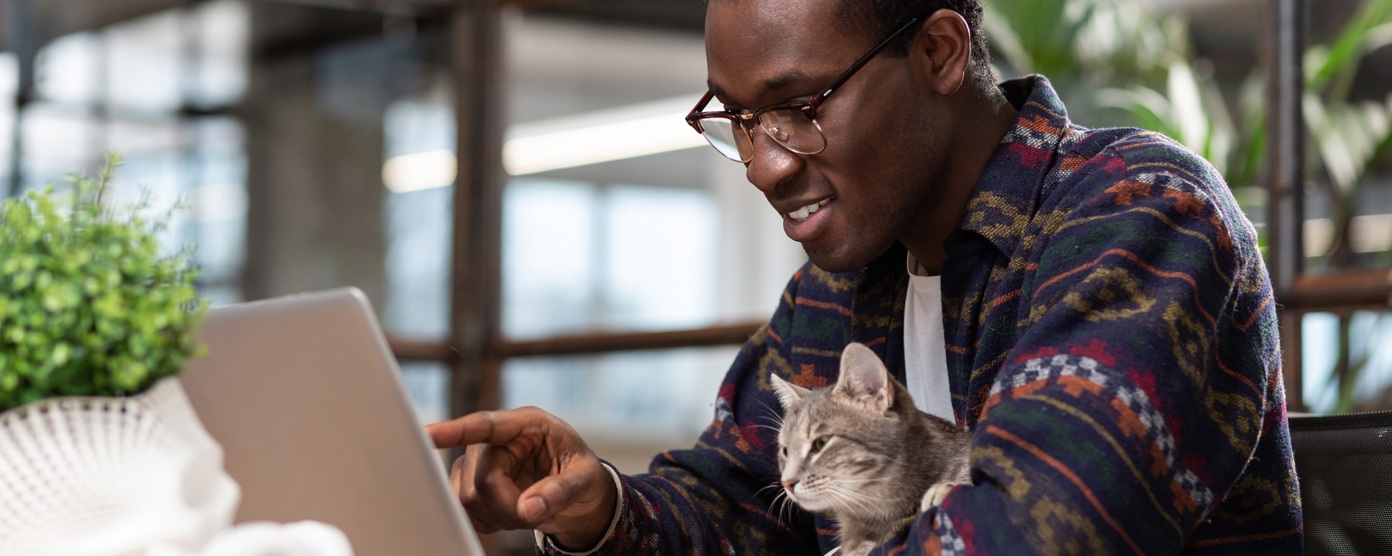Man sitting at his laptop with a cat on his lap