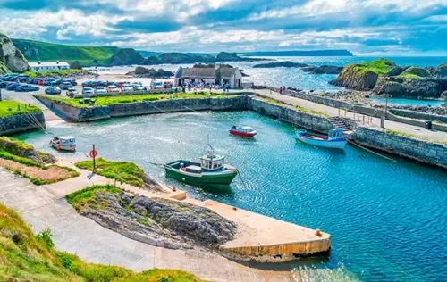 A vibrant harbor scene featuring several small boats floating in calm blue water.