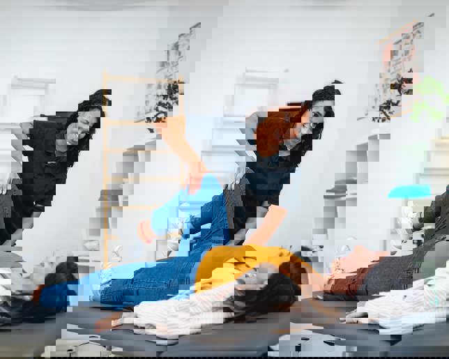 Physiotherapist assisting patient