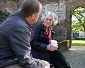 An older women and a mid-40s man chatting on a park bench.jpg