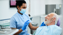 Dental nurse communicating with senior patient