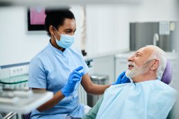 Dental nurse communicating with senior patient