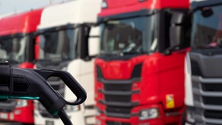Electric trucks with charger in foreground