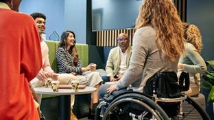 Inclusive team talking around a coffee table