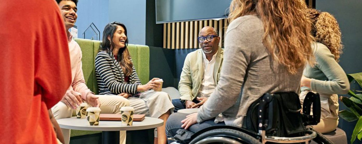 Inclusive team talking around a coffee table