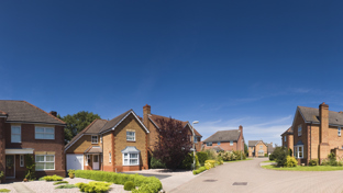 Row of modern brick houses on a quiet cul‑de‑sac under a clear blue sky.