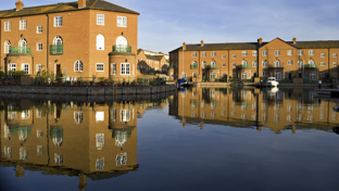 Luxury apartment blocks reflected in the water.