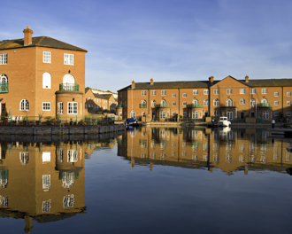 Luxury apartment blocks reflected in the water.