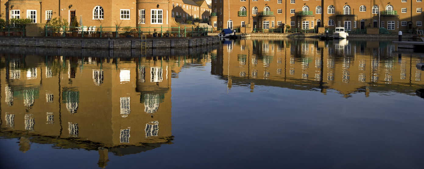 Luxury apartment blocks reflected in the water.