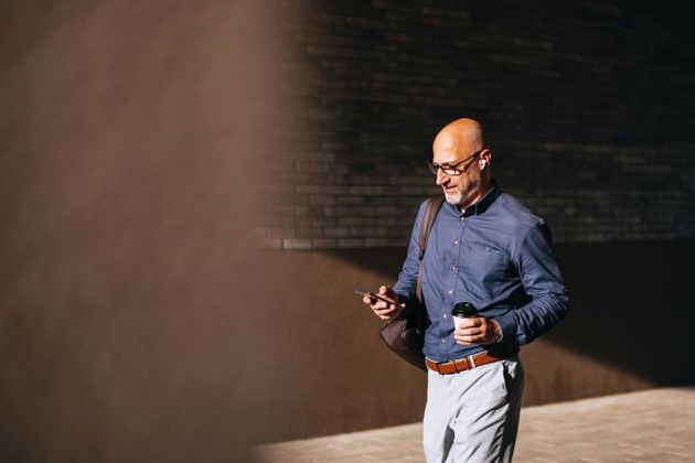 Professional male walking using his phone