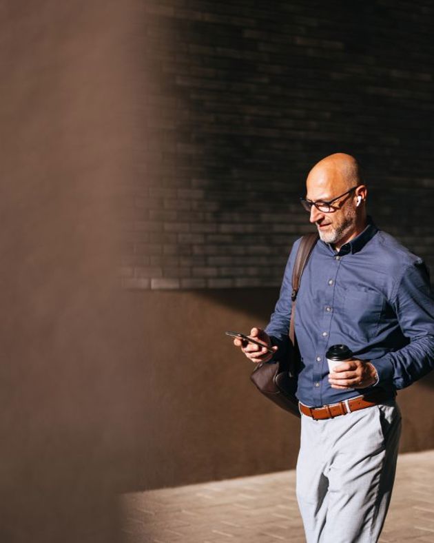 Professional male walking using his phone