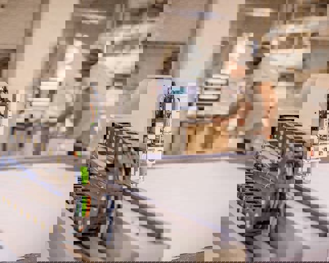 Factory worker operating CNC digital cutter for textile and fabric printing production