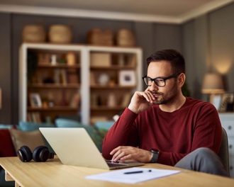 Man at his kitchen table using laptop