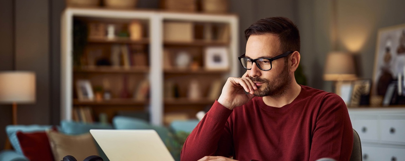Man at his kitchen table using laptop