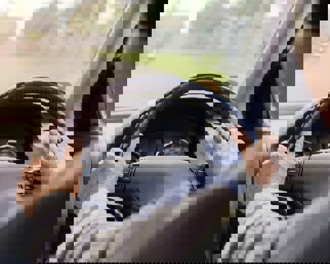 Senior adult hands on wheel