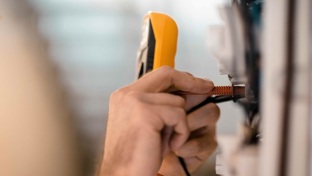 Close up of an electrician's hands doing a pat test