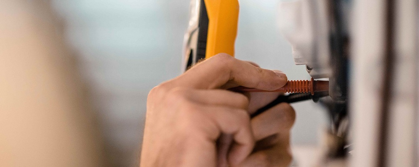 Close up of an electrician's hands doing a pat test