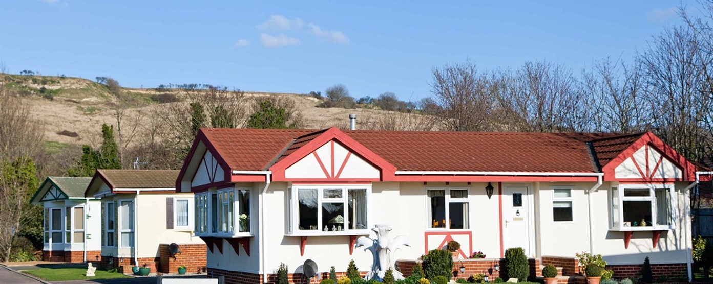 A park home with a fountain in front of it on a sunny day