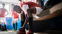 Football player tying shoelace