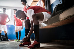 Football player tying shoelace